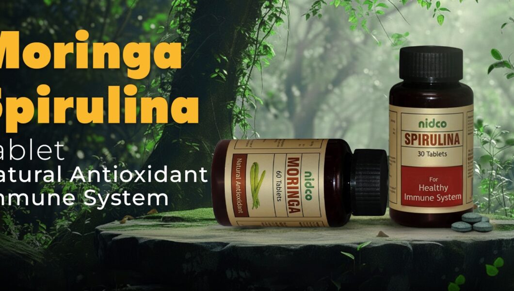 Fresh green moringa leaves and organic moringa powder in a wooden bowl.